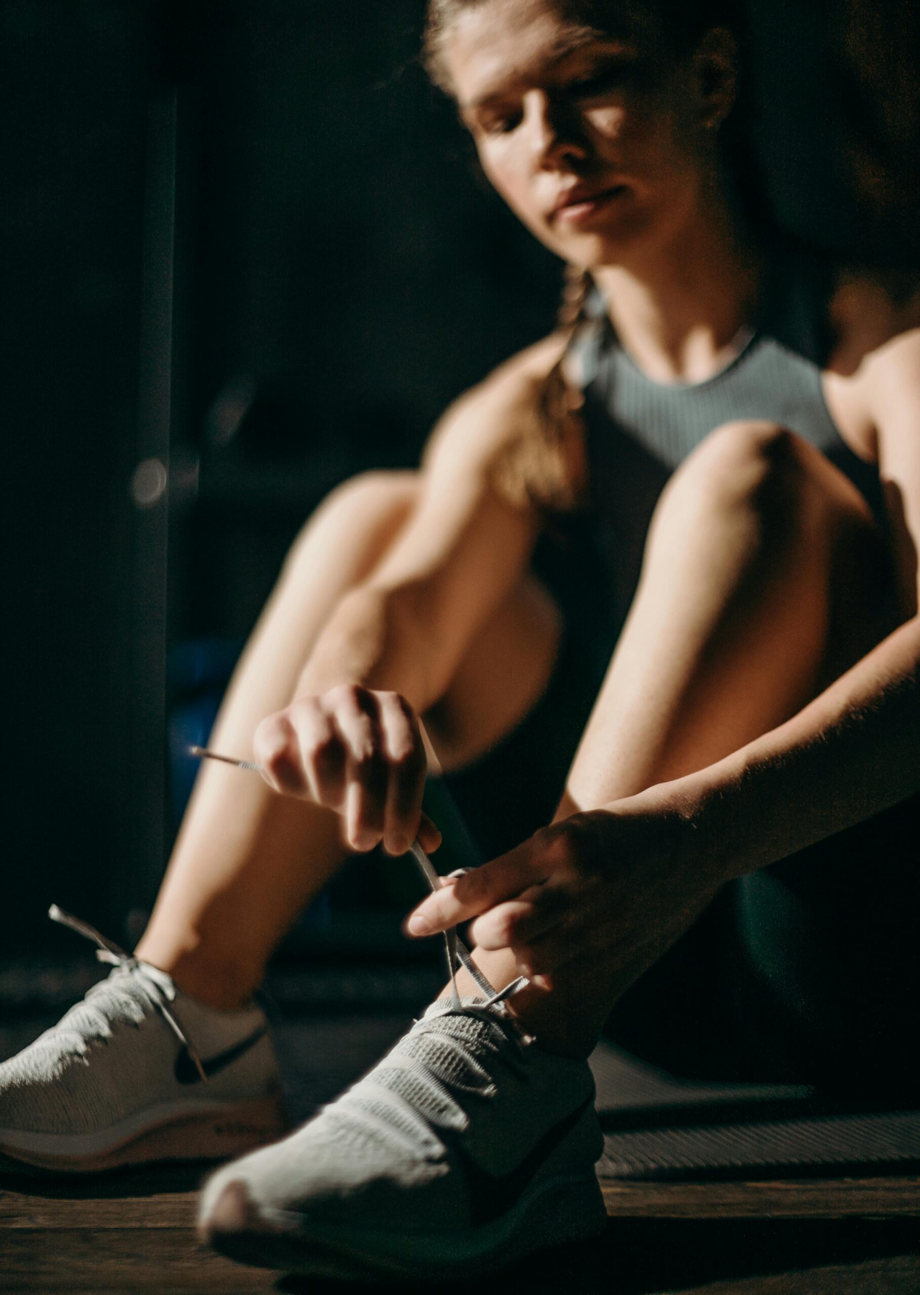 Женщина выполняет упражнение с гантелями в спортзале