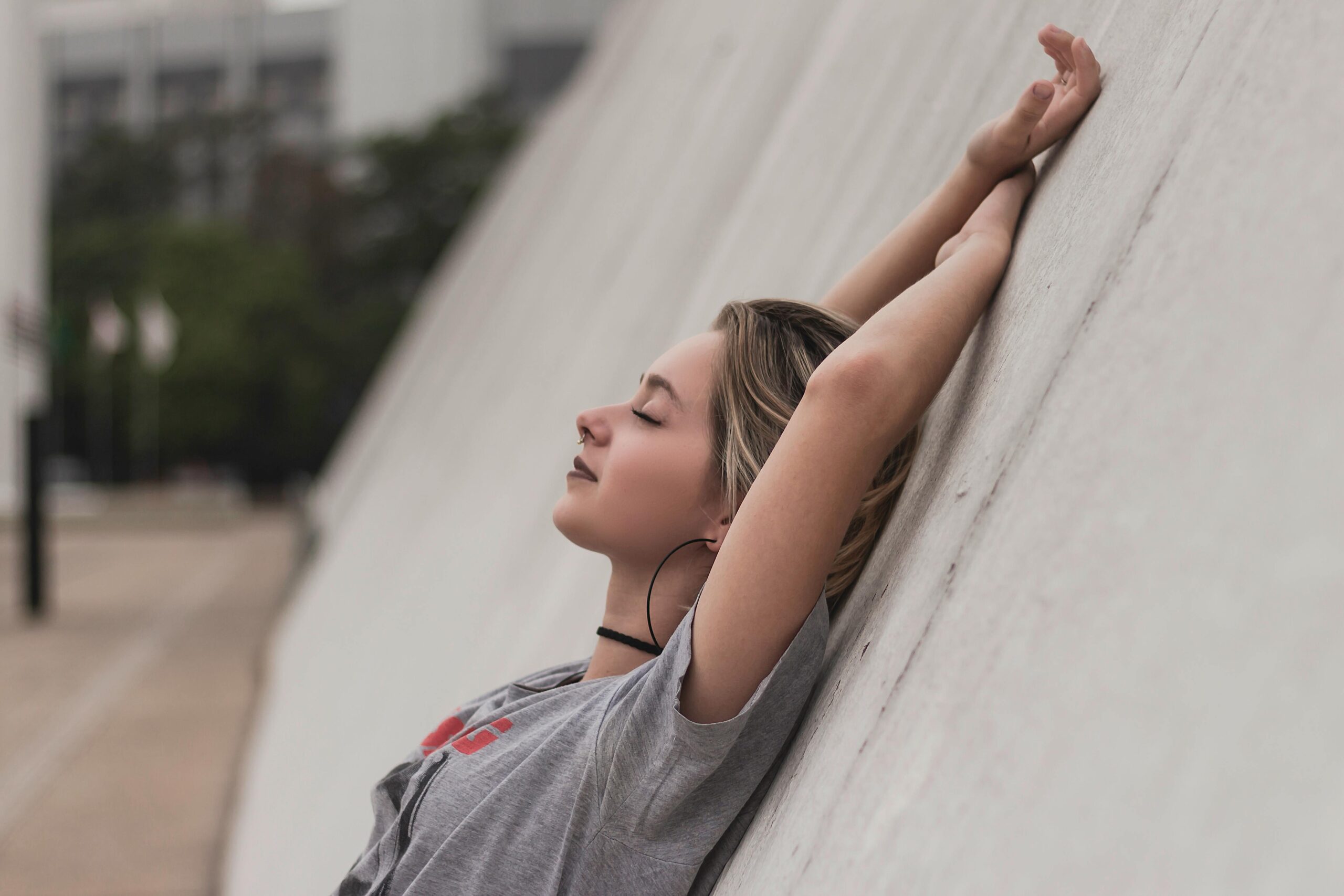 Женщина в наушниках слушает аудиокнигу на улице